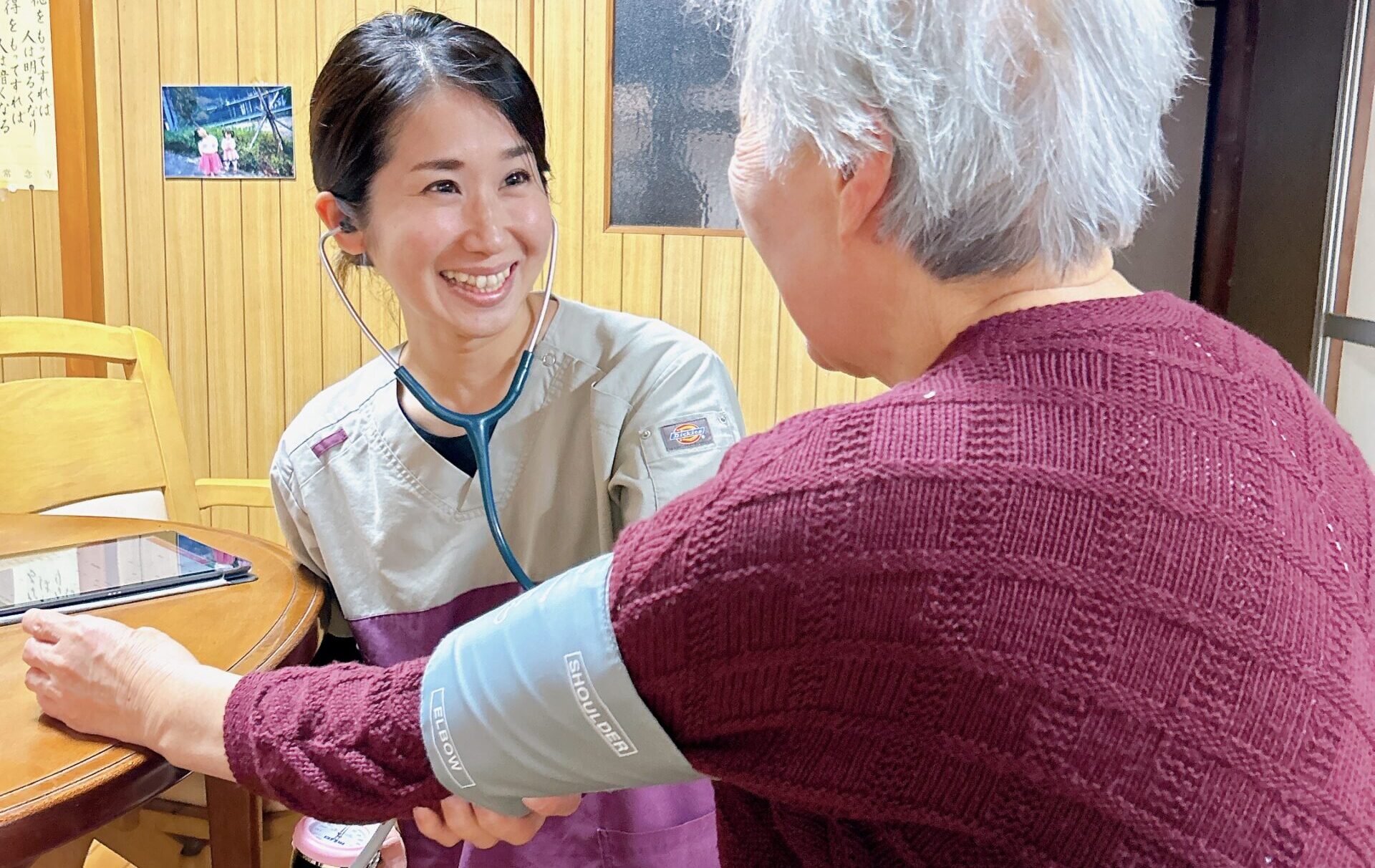 訪問看護師が利用者の血圧測定を行っている様子